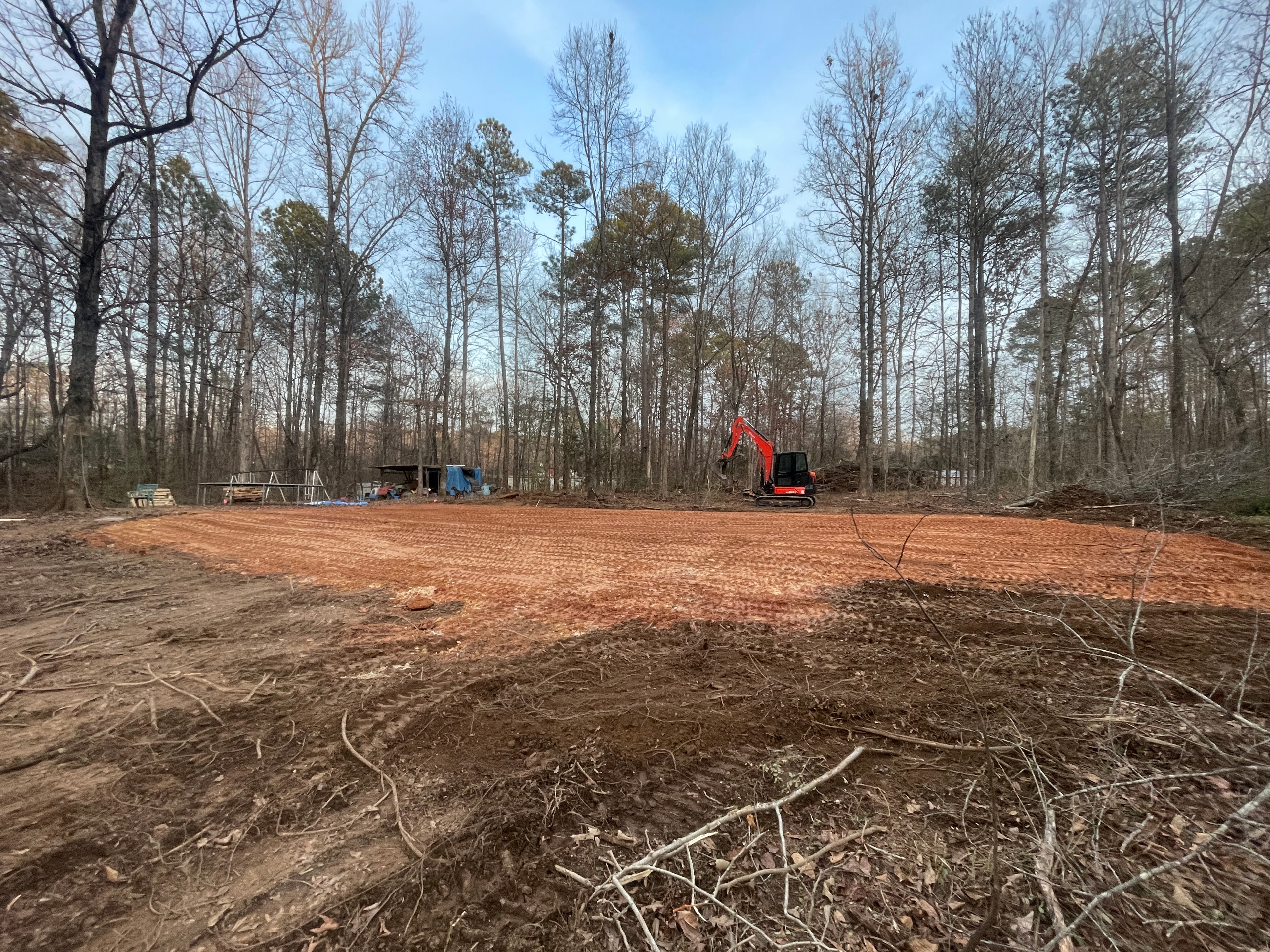 Red excavator clearing rural land